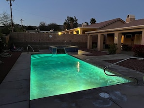 Pool and spa with color changing lights in the back yard. 
