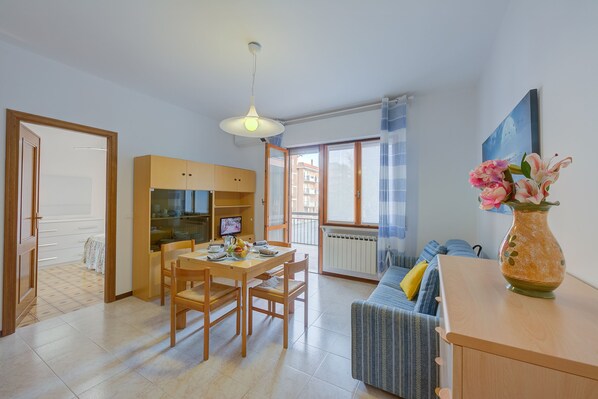 Living room with dining table, TV and sofa bed