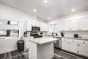 Vaulted, renovated kitchen with subway tile backsplash and brand new countertops