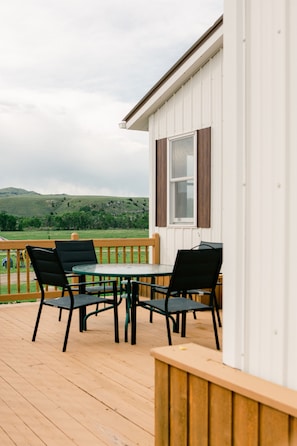 Porch with outdoor seating area and grille.