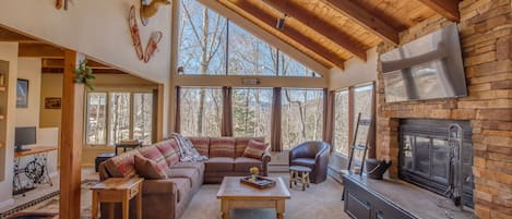 Living room with wood burning fireplace and 55" smart TV