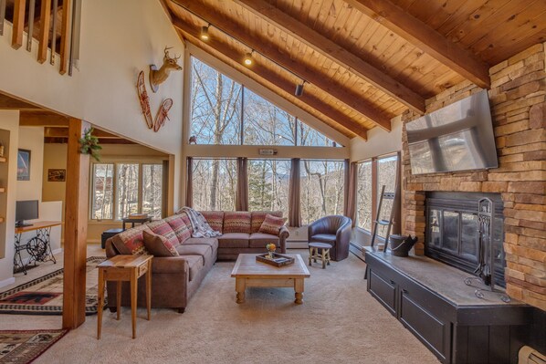 Living room with wood burning fireplace and 55" smart TV