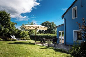 Veranda mit Holzkohlegrill und Sonnenschirm