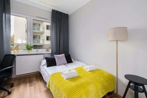 The stylish bedroom includes a comfortable sofa bed and a wardrobe.