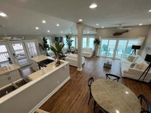 Open living, kitchen, & dining room with a 180 degree view of sugar white beach