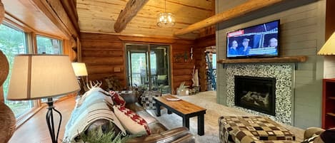 Vaulted living room with smart TV, Roku, Gas fireplace, Central air, fans, porch