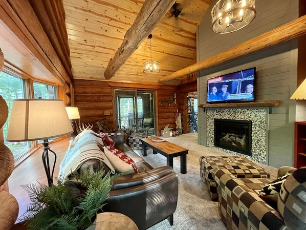 Vaulted living room with smart TV, Roku, Gas fireplace, Central air, fans, porch