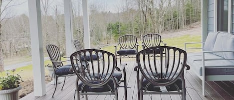 Enjoy the front porch, furnished with outdoor seating and a 12’ dining table. 