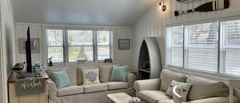 Comfortably cozy living room with coastal decor and plenty of light!
