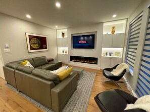 Living room with 65" Smart TV and electric fireplace with comfortable seating