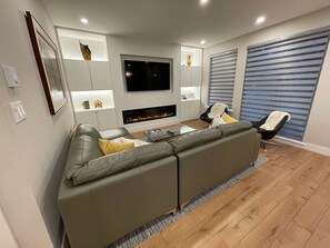Living room with 65" Smart TV and electric fireplace with comfortable seating
