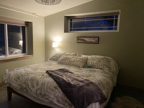 Bedroom with King Bed, big windows and adjoining bathroom. 