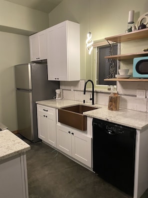 Beautiful kitchen with Farm sink, dishwasher, induction stove, and granite tops