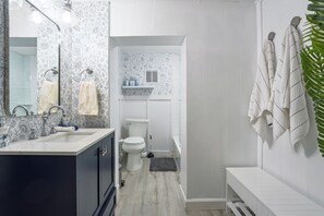 Costal Style renovated bathroom with a bathtub/shower combo & full body mirrors