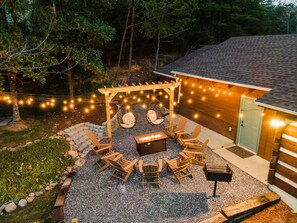 Fire pit area with ambient string lighting and a propane fire pit.