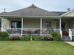 Relaxing, covered front porch with two entries to house