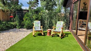 Schaukelstühle auf der Südterrasse mit großen Fenstertüren zum Wohnzimmer