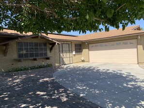 Front of the house. Driveway for 2-3 cars. House number on wall on N/S side.