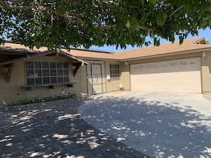 Front of the house. Driveway for 2-3 cars. House number on wall on N/S side.