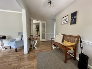 Entryway with bench and coat rack. Storage bin for shoes located under bench.