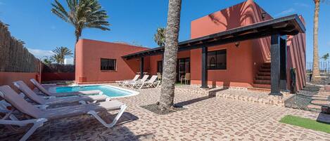 External view of the building. General view of patio, swimming-pool sun-lounger and all other itemsl