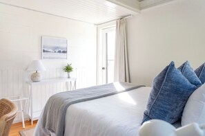 The secondary bedroom features a private deck with ocean glimpses, dedicated workspace, and AC (seasonally).