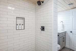 Bathroom features white-tiled walk-in shower