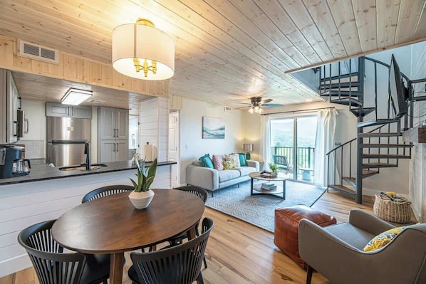 Open living & dining area with access stairs to loft. Kitchen is to the left of hallway.