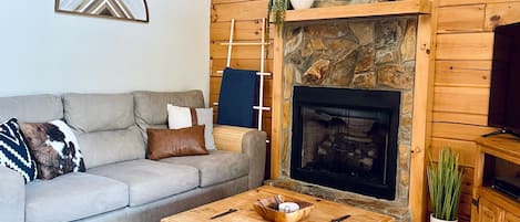 Main living area with gas log stone fireplace.