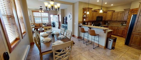 Entryway view of dining area, kitchen, and living room in the background.