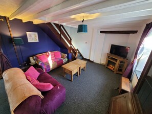 Living area with comfy sofas and electric flame effect fire.  Smart TV.