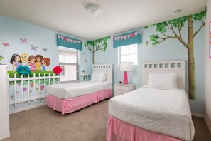This whimsical suite with pink skirting and twin beds will charm the kids.