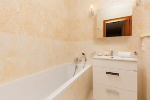 The bathroom features a modern bathtub and sleek fixtures.