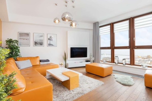 The living room features a sleek coffee table and a flat-screen television.