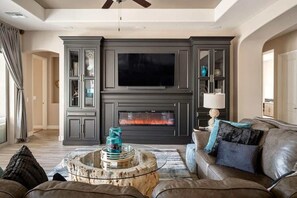 Fabulous living room with a comfy couch, built in fireplace, TV and book shelfs.