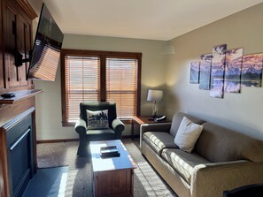 Main living space features a gas fireplace and a pull out sofa bed for 2 more guests. 