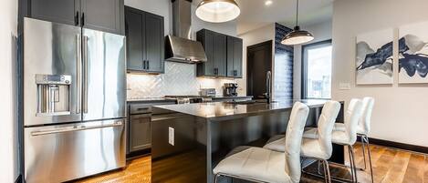 1st unit: Fully equipped kitchen with stainless steel appliances and breakfast bar seating