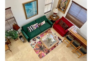 View from upstairs  hallway. Bar stools on right of chair, organ on left of sofa