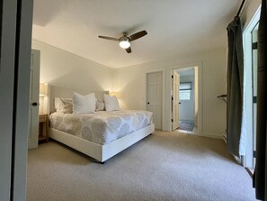 Primary bedroom with king bed, en suite full bathroom, and door to deck