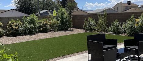 Private yard with turf and sitting area. 