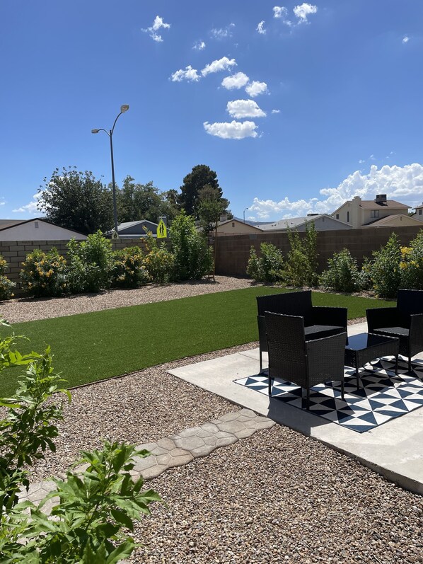 Private yard with turf and sitting area. 