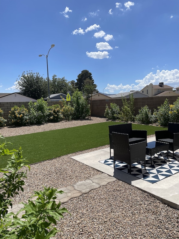 Private yard with turf and sitting area. 