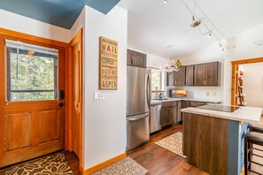 Step into the quaint kitchen with stainless steel appliances and tidy counter space