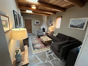 Living room with traditional Kiva Fireplace and Viga ceiling