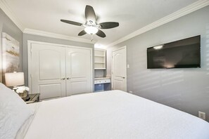 Bedroom with queen bed. Smart TV, closet, hangers and desk area