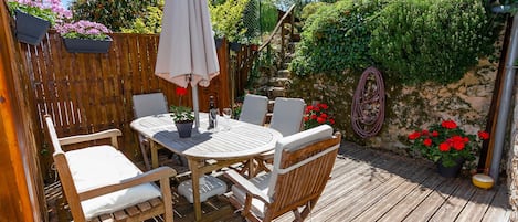 Une terrasse bien ensoleillée pour des repas, la détente, avec deux parasols