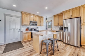 Updated kitchen with center island and stainless steel appliances.