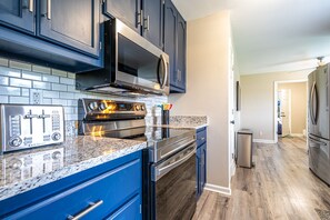 Gleaming kitchen, complete with full sized appliances, granite counters