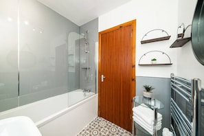 Bathroom with shower over bath and heated towel rail.