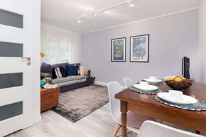 A view of the spacious living room with a comfortable sofa harmoniously connected to the dining area.
